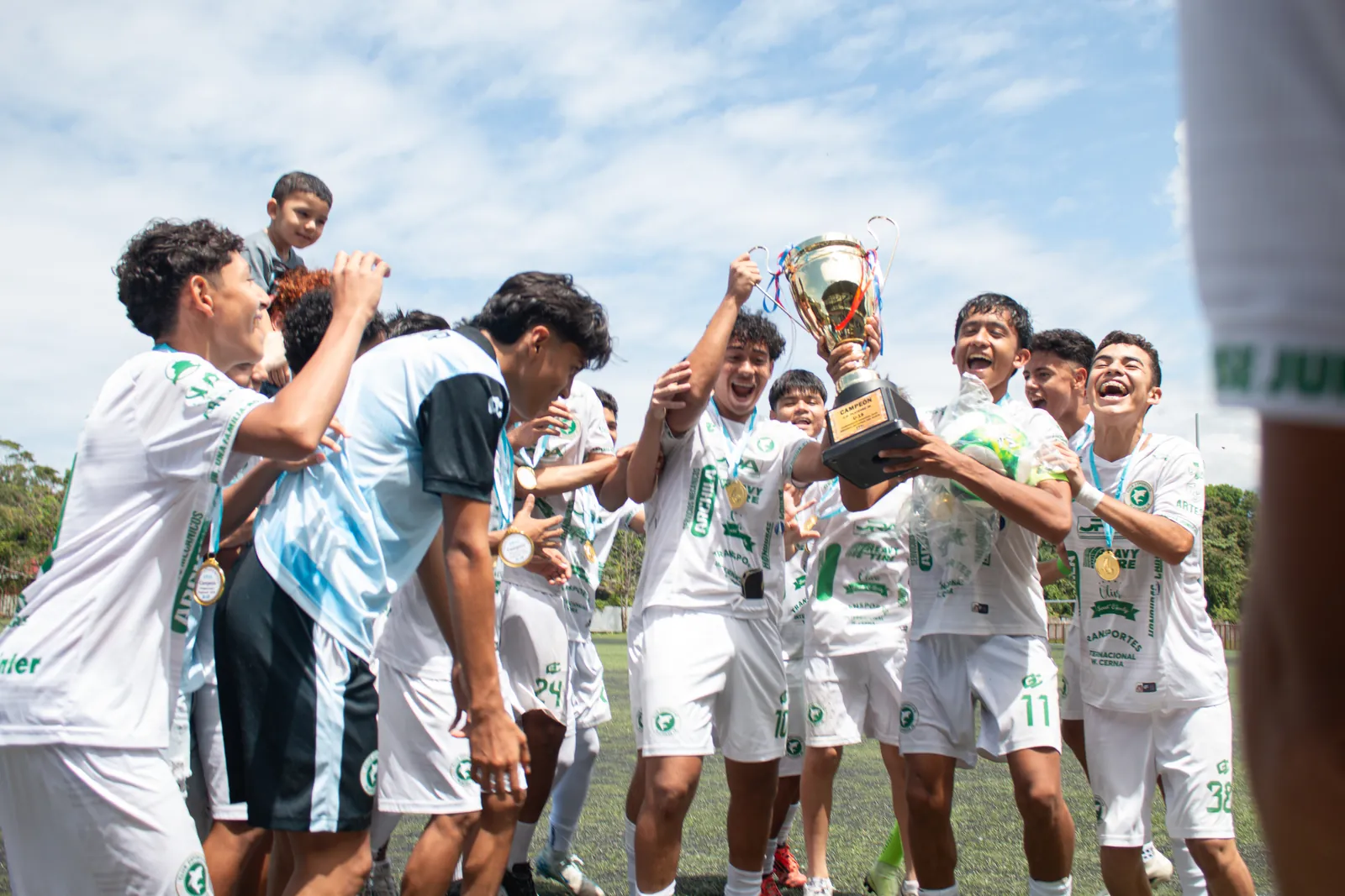 Jugadores celebrando con las copas del campeonato regional